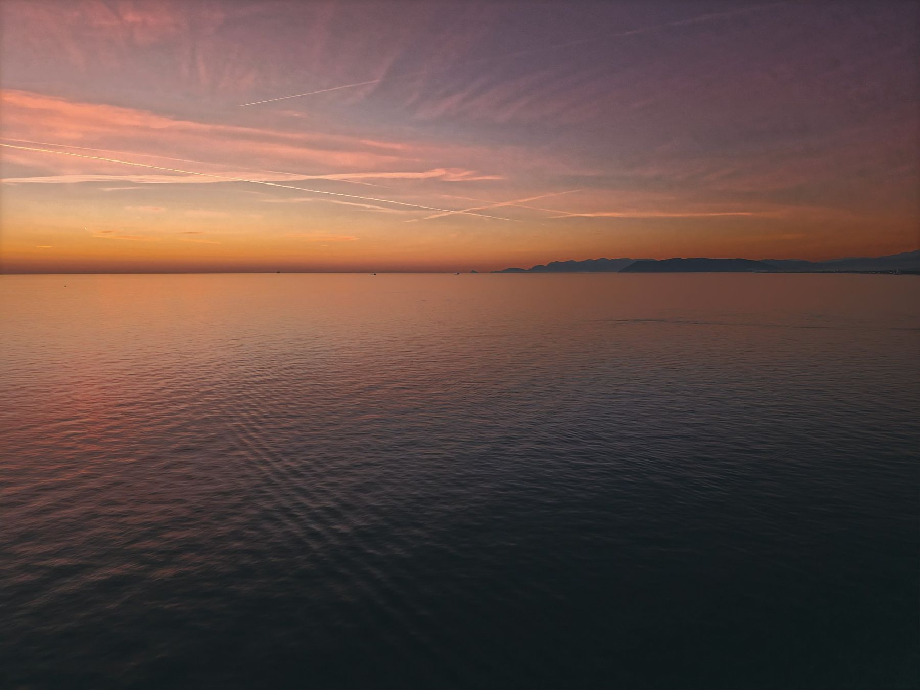 Il mare della Versilia al tramonto, con la costa all'orizzonte